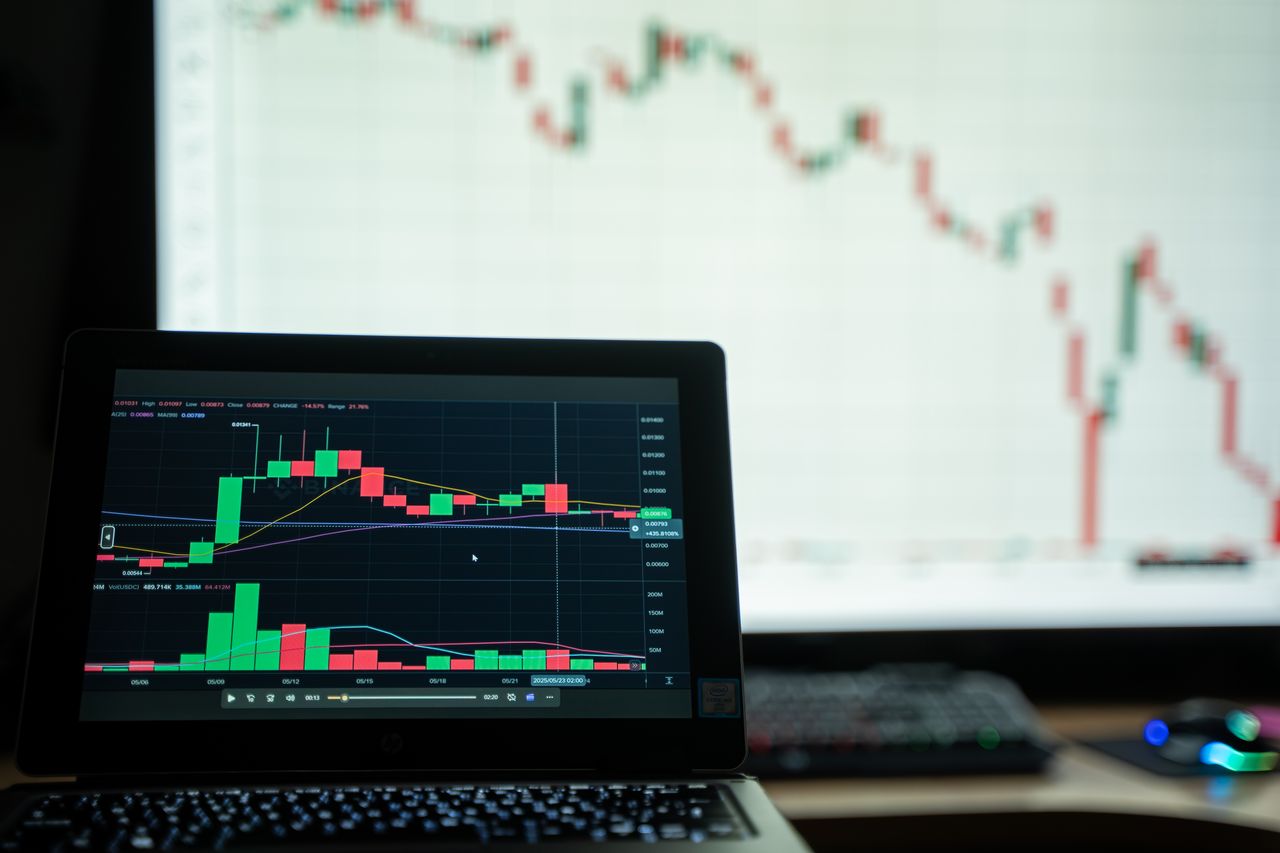 Close-up of a laptop showing cryptocurrency market charts in a trading environment.